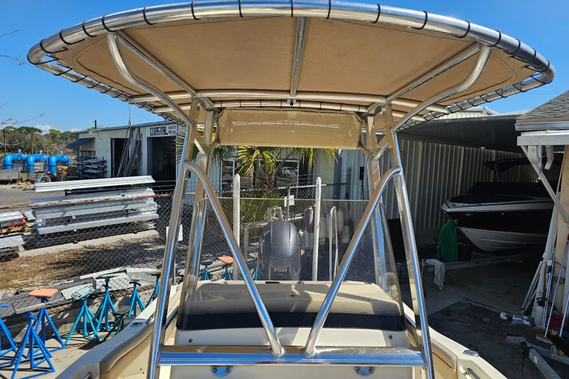 Slide: The Image of 2016 Scout 210 XSF boat with T-top in a marina setting. - 23