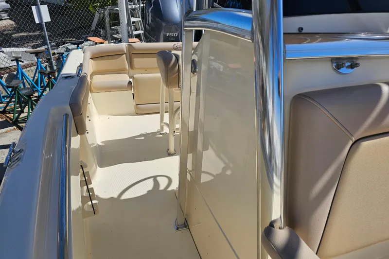 Slide: The Image of 2016 Scout 210 XSF boat interior with beige seating and stainless steel accents. - 24