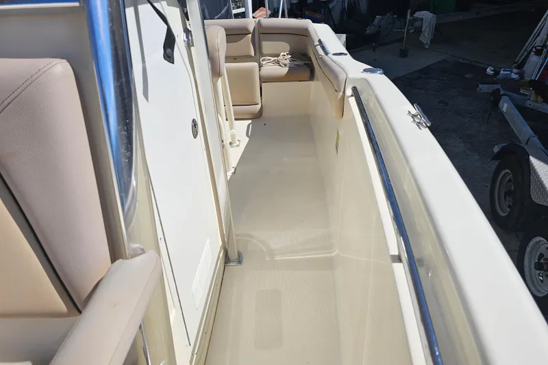 Slide: The Image of 2016 Scout 210 XSF boat interior with beige seating and white deck. - 25