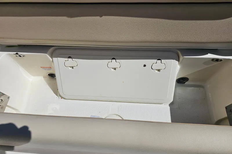 Slide: The Image of 2016 Scout 210 XSF boat storage compartment with beige seating and white interior. - 27