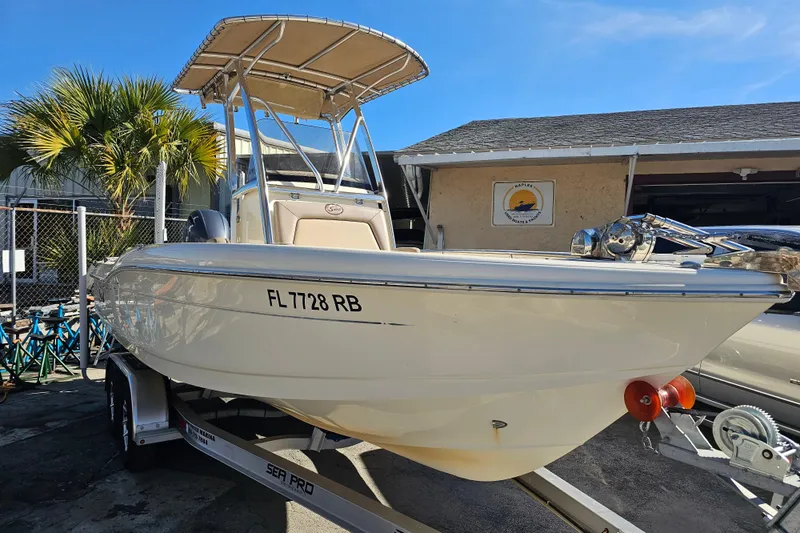 Slide: The Image of 2016 Scout 210 XSF boat on stands, palm trees in background. - 3