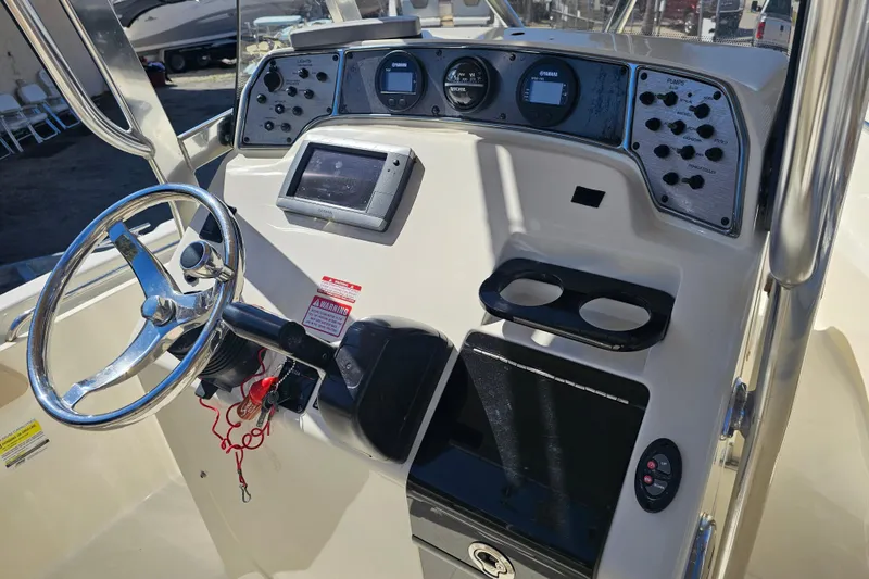 Slide: The Image of 2016 Scout 210 XSF boat dashboard with steering wheel and control panel. - 32