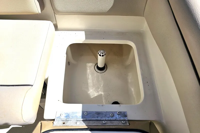Slide: The Image of 2016 Scout 210 XSF boat storage compartment with drain plug, beige interior. - 36