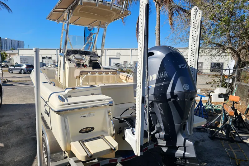 Slide: The Image of 2016 Scout 210 XSF boat with Yamaha 150 engine, parked outdoors. - 5