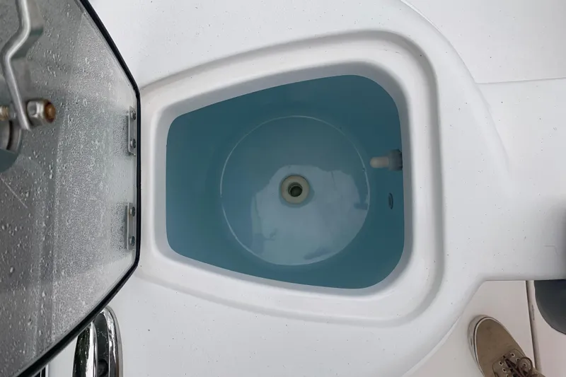 Slide: The Image of Livewell on 2015 Tidewater 220 CC Adventure boat, open lid, blue interior. - 13