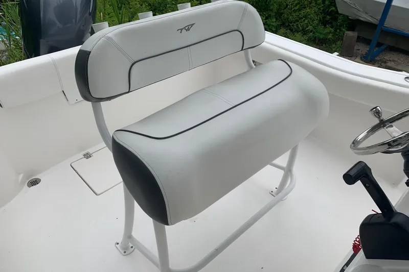 Slide: The Image of 2015 Tidewater 220 CC Adventure boat interior with white seating and steering wheel. - 8