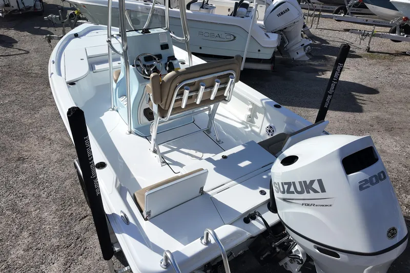Slide: The Image of 2026 Blazer PureBay 2200 boat with Suzuki 200 engine, parked on gravel. - 3