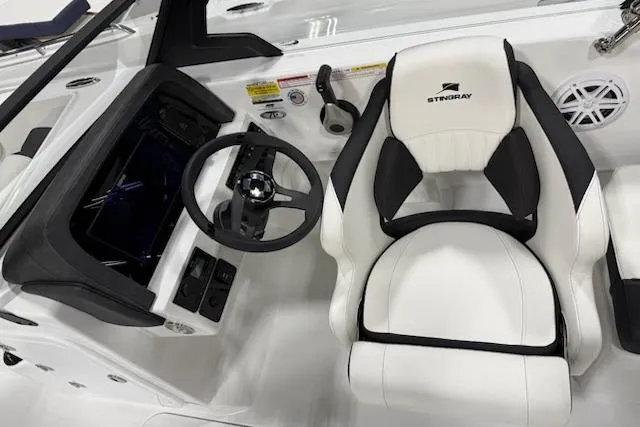Slide: The Image of 2026 Stingray 20 SBX boat cockpit with steering wheel and white captain's chair. - 3