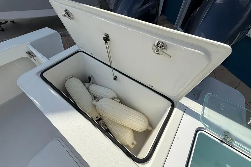 Slide: The Image of Open storage compartment on 2023 Parker 2520 XLD Sport Cabin boat with fenders inside. - 14