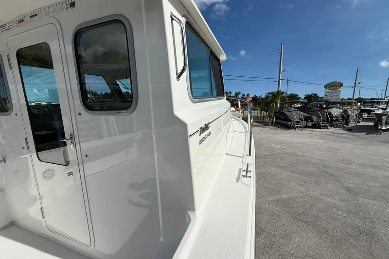 Slide: The Image of 2023 Parker 2520 XLD Sport Cabin boat exterior view in a sunny marina. - 17