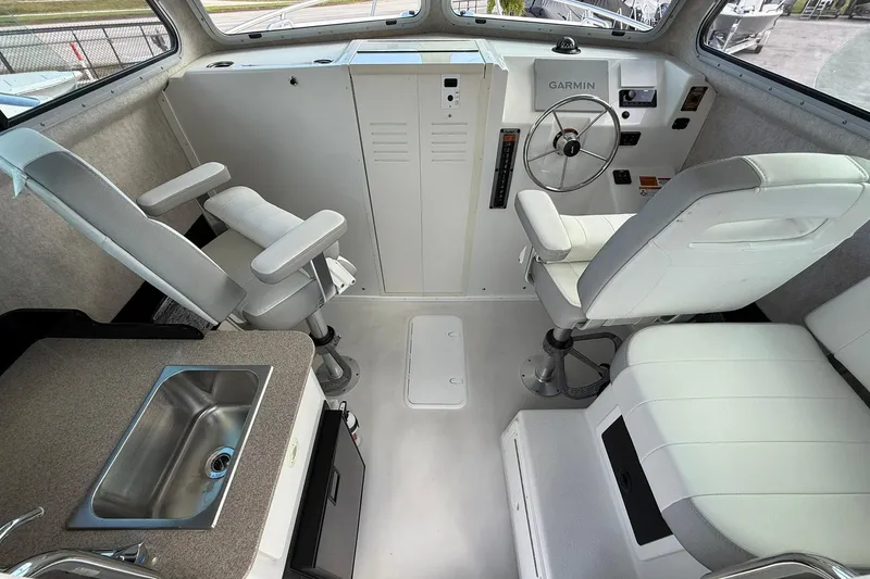 Slide: The Image of Interior of 2023 Parker 2520 XLD Sport Cabin with helm, seating, and sink. - 24