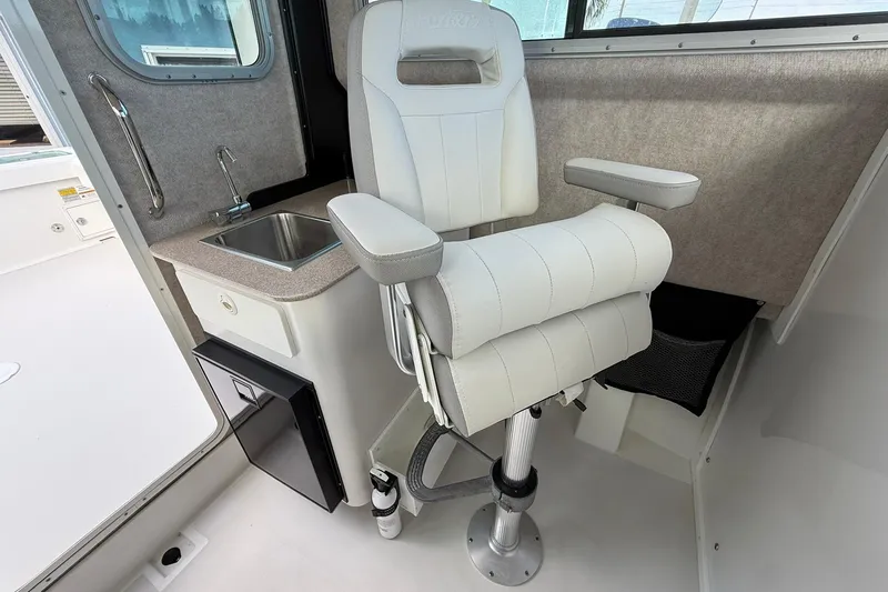 Slide: The Image of 2023 Parker 2520 XLD Sport Cabin interior with captain's chair and sink. - 25