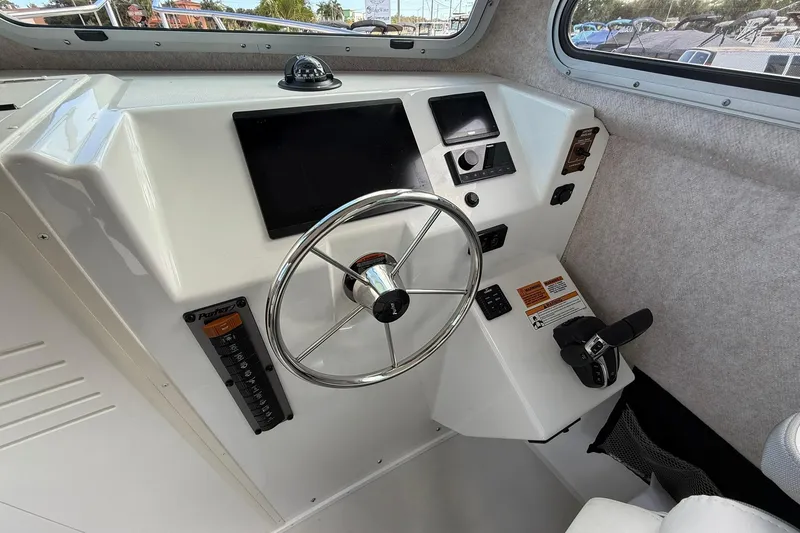 Slide: The Image of 2023 Parker 2520 XLD Sport Cabin helm with steering wheel and control panel. - 27