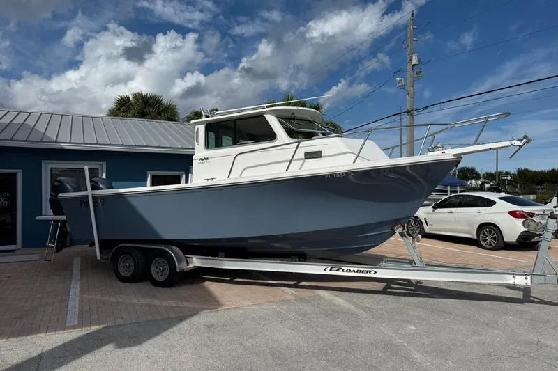 Slide: The Image of 2023 Parker 2520 XLD Sport Cabin boat on trailer, parked outside a building. - 4