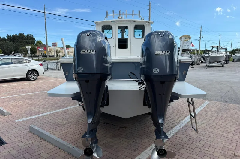 Slide: The Image of 2023 Parker 2520 XLD Sport Cabin with dual Yamaha 200 engines, parked outdoors. - 6
