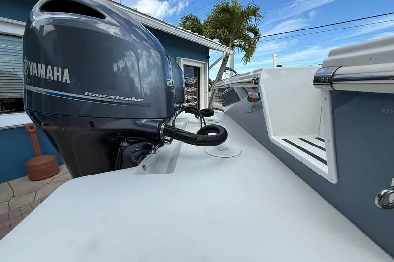 Slide: The Image of 2023 Parker 2520 XLD Sport Cabin with Yamaha four-stroke engine, docked near a blue building. - 7