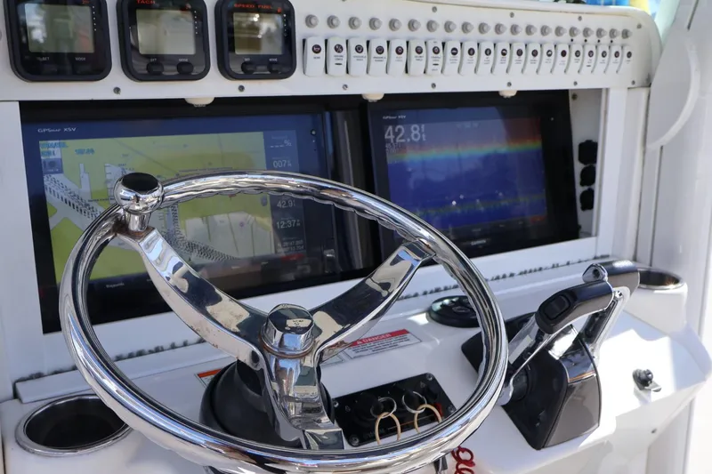Slide: The Image of 2011 Everglades 320 Center Console dashboard with steering wheel and navigation screens. - 10
