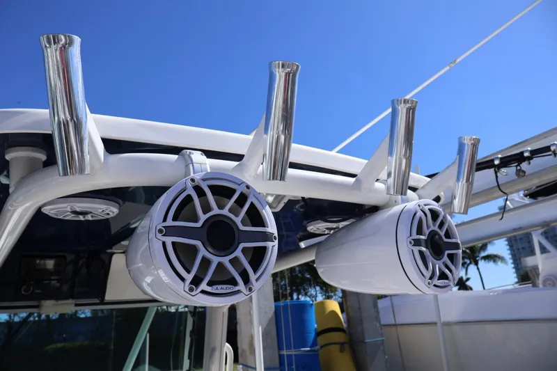 Slide: The Image of 2011 Everglades 320 Center Console boat with speakers and rod holders under clear blue sky. - 13