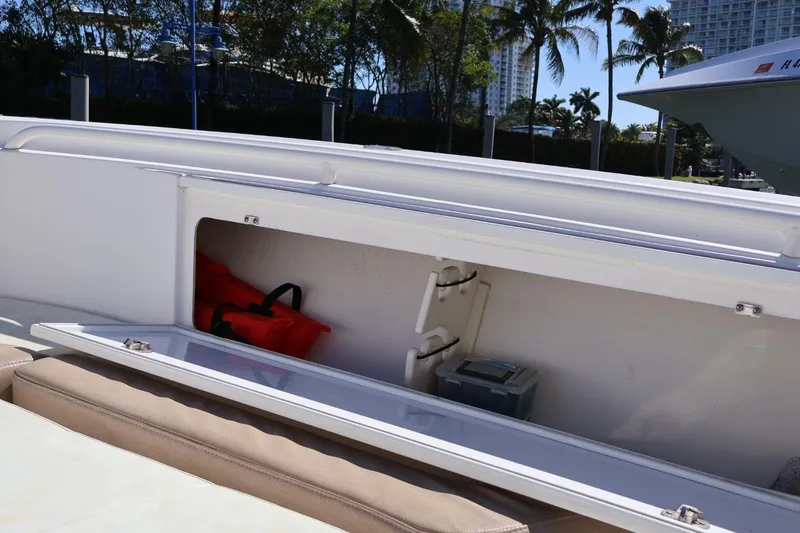 Slide: The Image of 2011 Everglades 320 Center Console boat storage compartment with safety gear and equipment. - 18