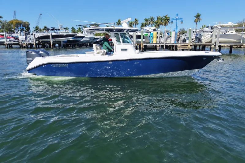 Slide: The Image of 2011 Everglades 320 Center Console boat cruising near a marina on a sunny day. - 4