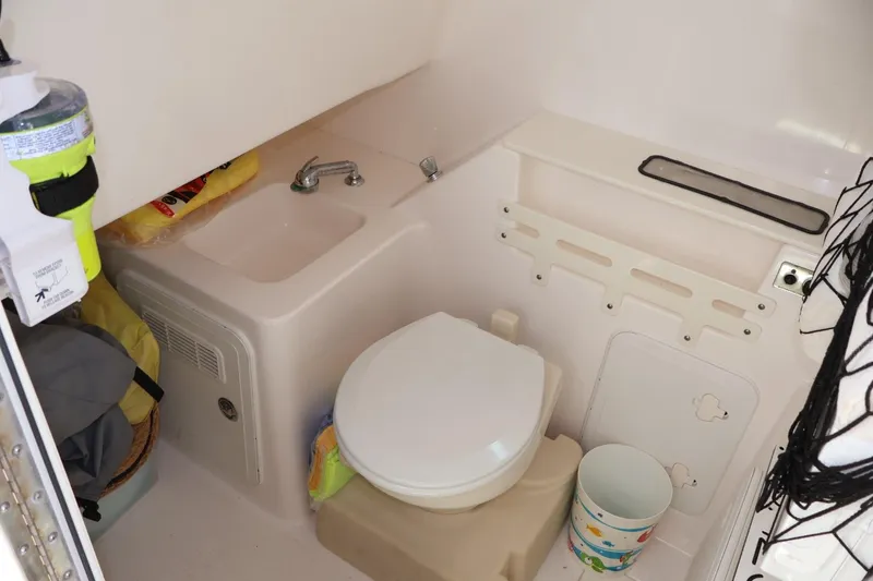Slide: The Image of 2011 Everglades 320 Center Console boat bathroom with sink and toilet. - 9