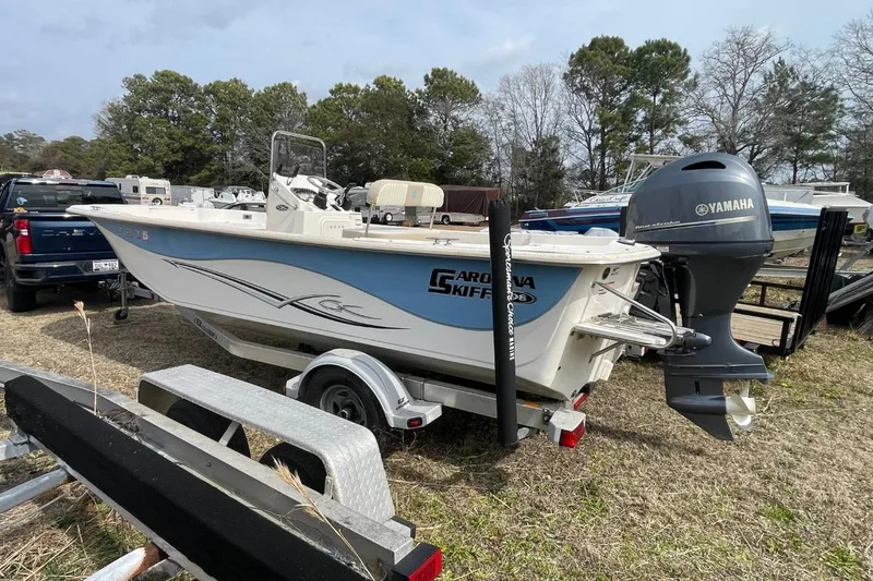 Slide: The Image of 2019 Carolina Skiff 198 DLV boat with Yamaha motor on trailer, parked outdoors. - 1