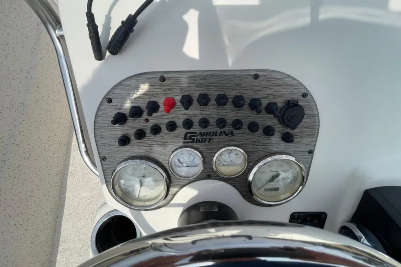 Slide: The Image of Control panel of a 2019 Carolina Skiff 198 DLV boat with gauges and switches. - 13