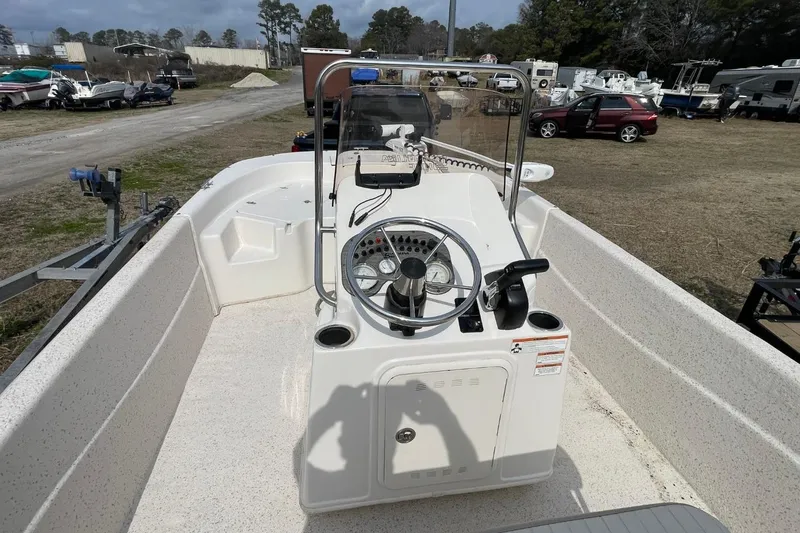 Slide: The Image of 2019 Carolina Skiff 198 DLV boat interior with steering console, parked outdoors. - 19