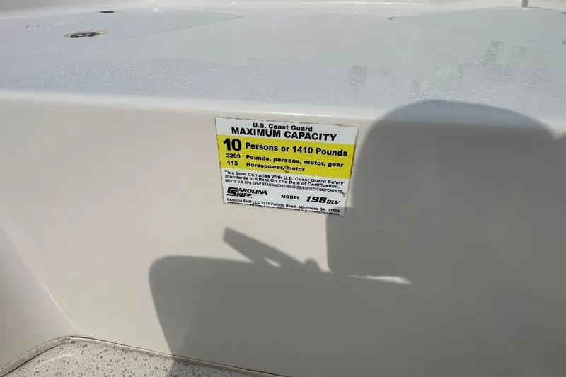 Slide: The Image of 2019 Carolina Skiff 198 DLV capacity label, 10 persons or 1410 pounds limit. - 23