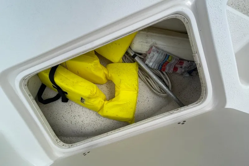 Slide: The Image of Storage compartment in 2019 Carolina Skiff 198 DLV with yellow life jackets and rope. - 24