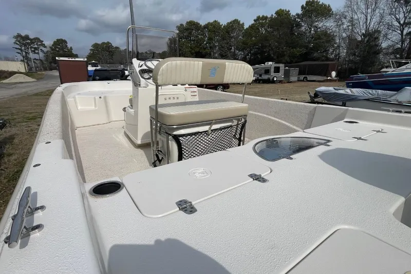 Slide: The Image of 2019 Carolina Skiff 198 DLV boat with seating and console, parked outdoors. - 8