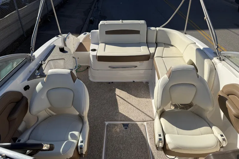 Slide: The Image of 2015 Chaparral 244 Sunesta boat interior with beige seating and carpeted floor. - 10