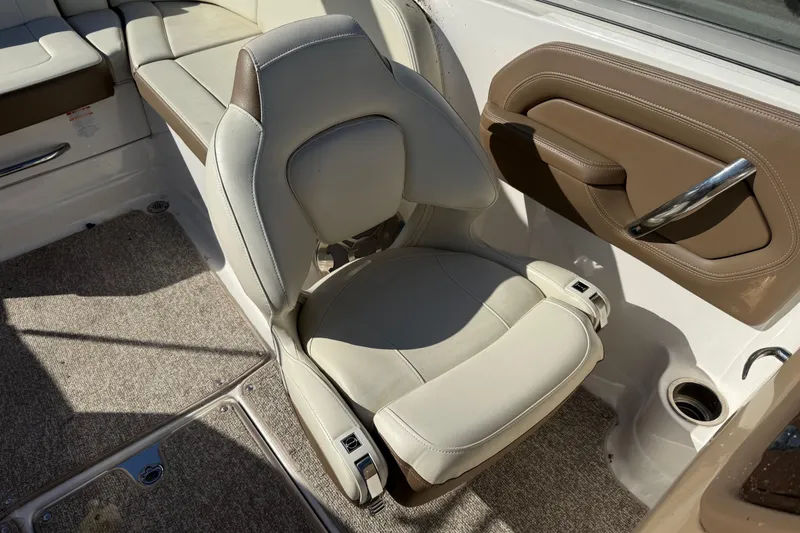 Slide: The Image of 2015 Chaparral 244 Sunesta boat interior with beige seating and carpeted flooring. - 11