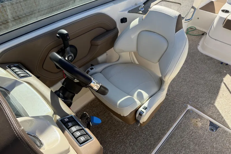 Slide: The Image of 2015 Chaparral 244 Sunesta boat cockpit with steering wheel and captain's chair. - 14