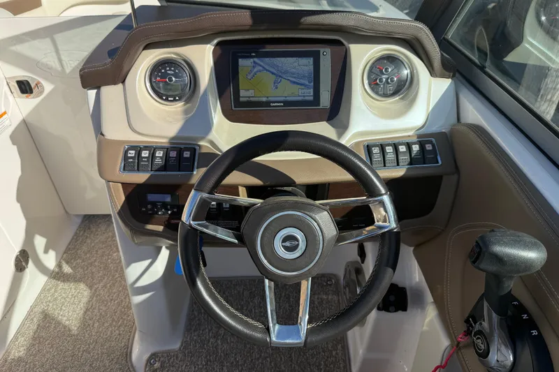Slide: The Image of 2015 Chaparral 244 Sunesta dashboard with steering wheel, GPS, and control panel. - 15
