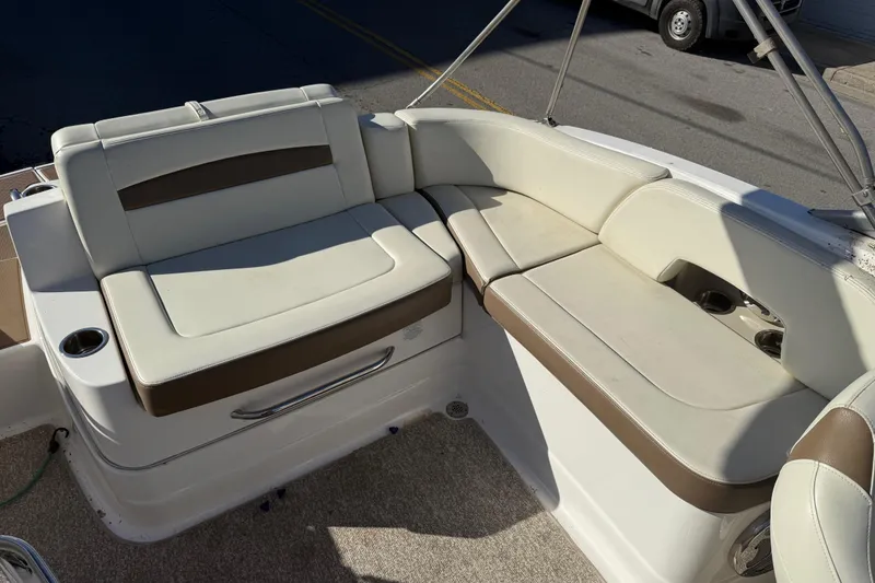 Slide: The Image of 2015 Chaparral 244 Sunesta boat interior with beige seating and cup holders. - 19