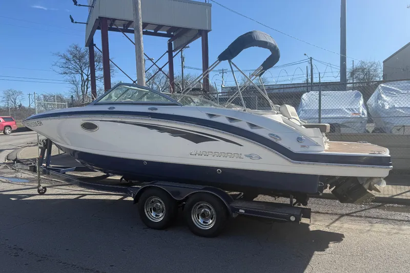 Slide: The Image of 2015 Chaparral 244 Sunesta boat on trailer, parked outdoors under clear sky. - 2