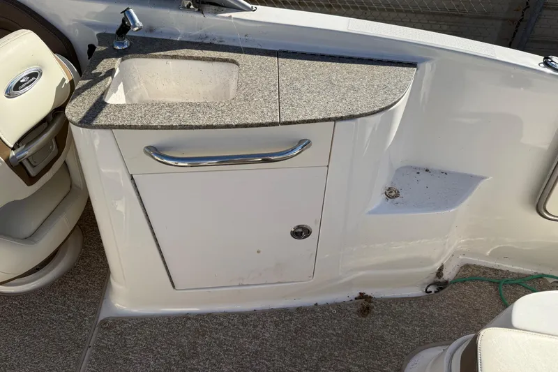 Slide: The Image of 2015 Chaparral 244 Sunesta boat interior with sink and storage cabinet. - 20