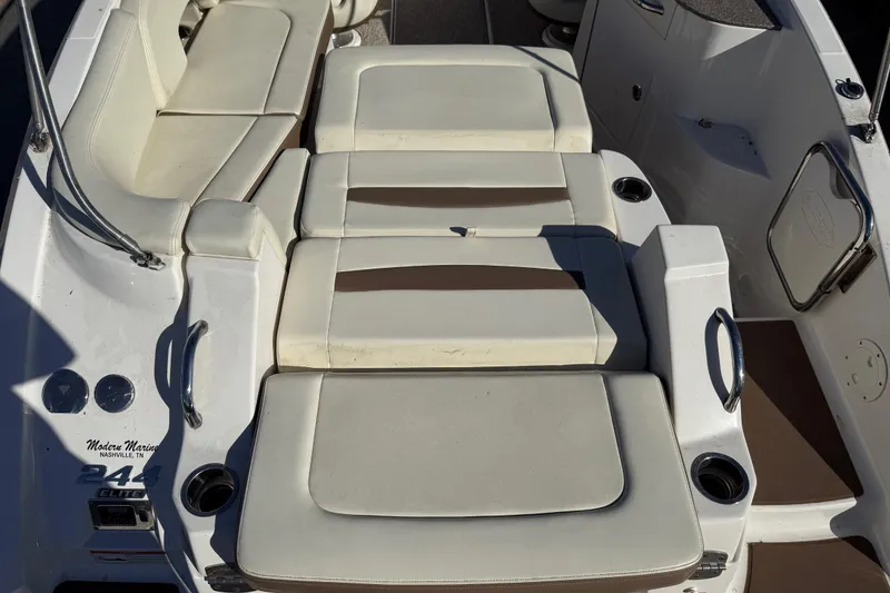 Slide: The Image of 2015 Chaparral 244 Sunesta boat interior with cushioned seating and cup holders. - 22