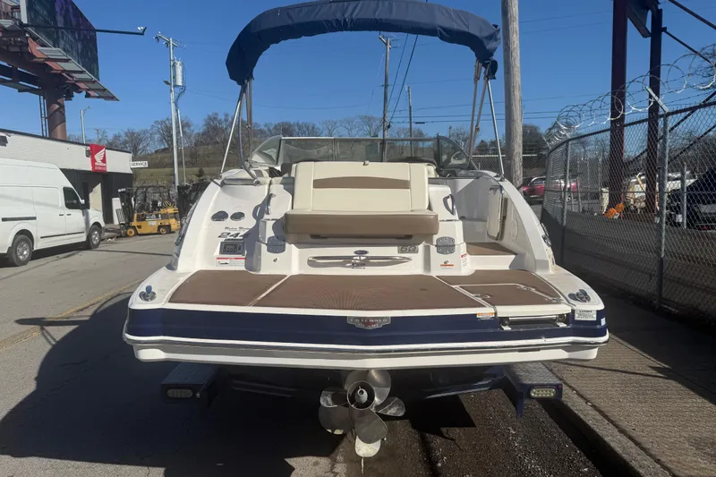 Slide: The Image of 2015 Chaparral 244 Sunesta boat with blue canopy, parked on a street. - 3