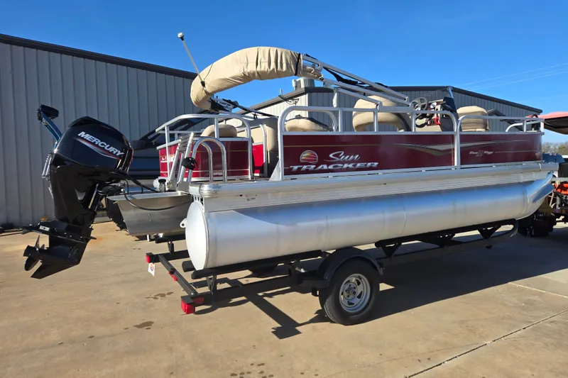 Slide: The Image of 2023 Sun Tracker Bass Buggy 18 DLX pontoon boat with Mercury engine on trailer. - 2