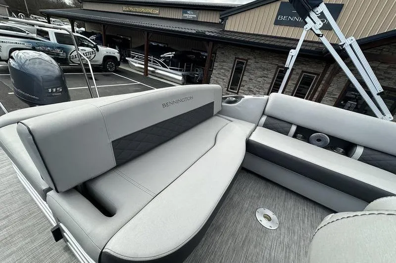 Slide: The Image of 2021 Bennington 21 SSBX pontoon boat with gray seating, parked at dealership. - 19