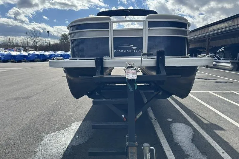 Slide: The Image of 2021 Bennington 21 SSBX pontoon boat on trailer in parking lot under cloudy sky. - 7