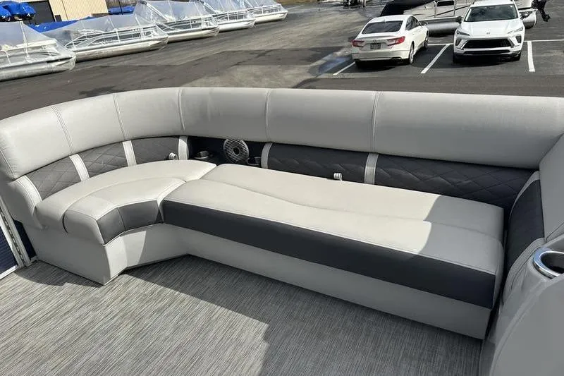 Slide: The Image of 2021 Bennington 21 SSBX pontoon boat interior with gray seating and parking lot background. - 9