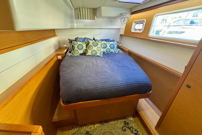 Slide: The Image of Cozy cabin interior of 2012 Lagoon 450 F yacht with bed and porthole window. - 17