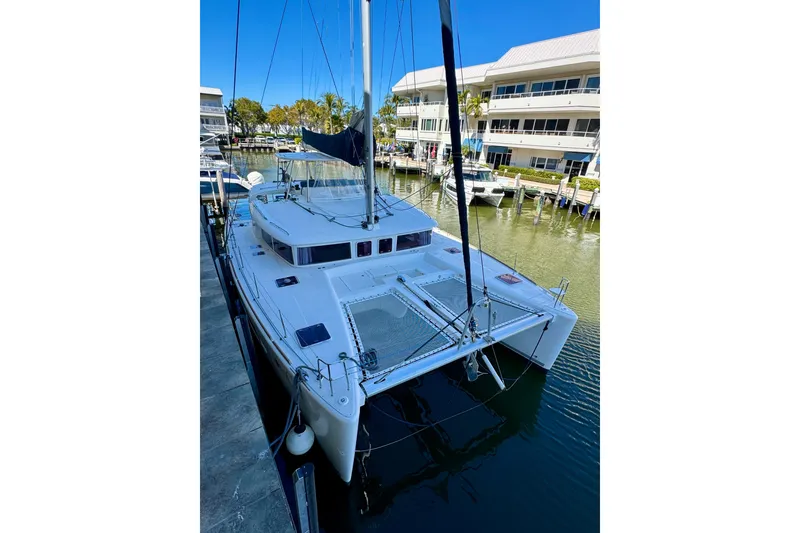Slide: The Image of 2012 Lagoon 450 F catamaran docked in marina, clear blue sky. - 2