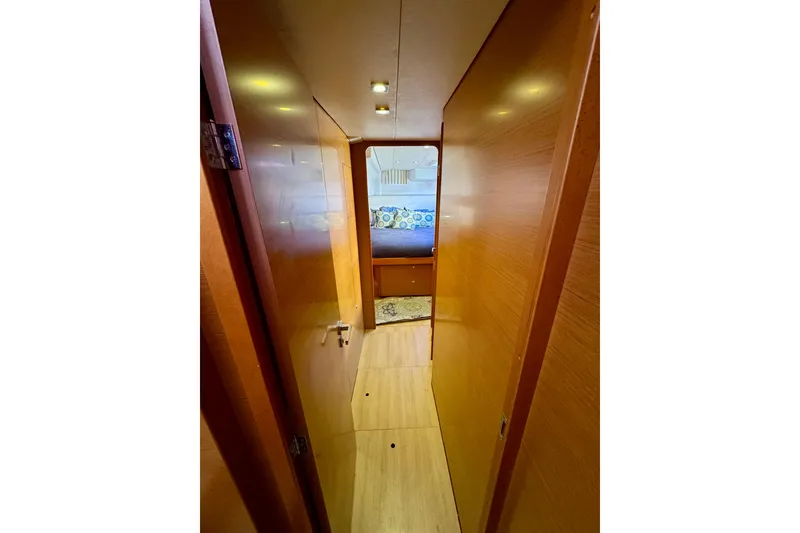 Slide: The Image of Interior hallway of 2012 Lagoon 450 F catamaran, featuring wooden paneling and cozy cabin view. - 22