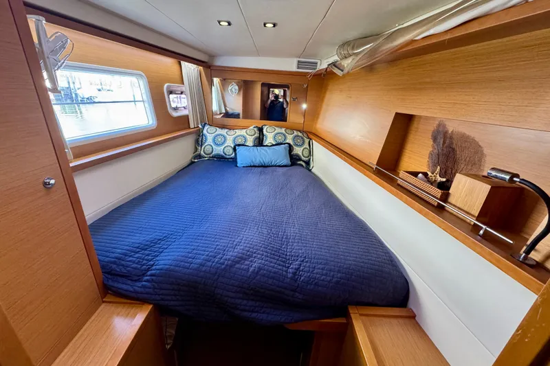 Slide: The Image of Cozy cabin interior of 2012 Lagoon 450 F yacht with blue bedding and wooden accents. - 23