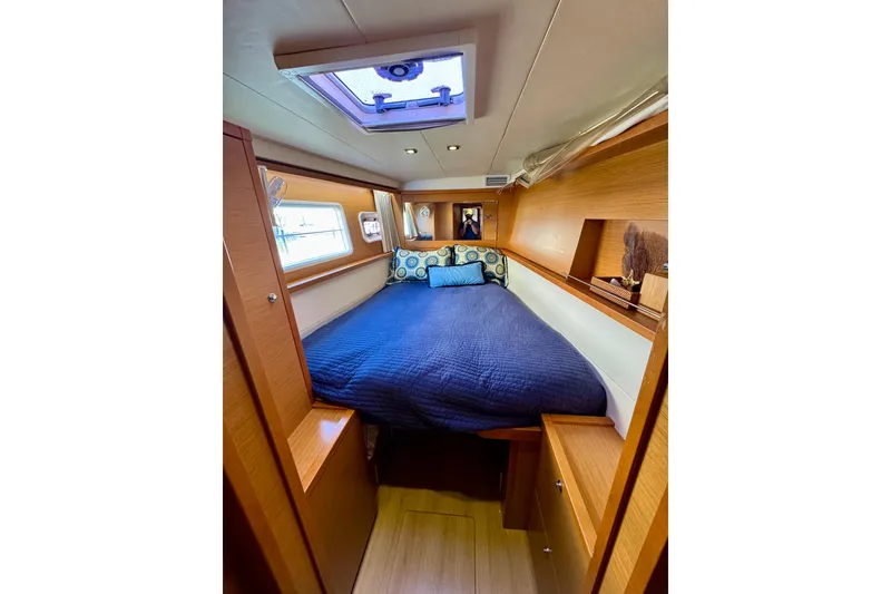 Slide: The Image of Cozy cabin interior of 2012 Lagoon 450 F yacht with blue bedding and wooden accents. - 24