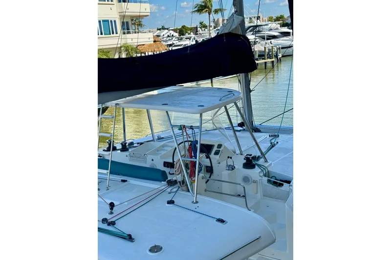 Slide: The Image of 2012 Lagoon 450 F catamaran docked, showcasing helm and deck area. - 4